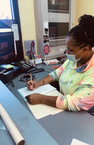 Ms. Edwina in the school's office working. 