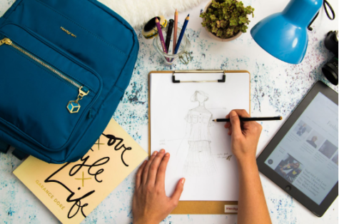 A student illustrates their clothing design for their fashion class. Retrieved from Pexels. Photo by Ray Piedra.  
