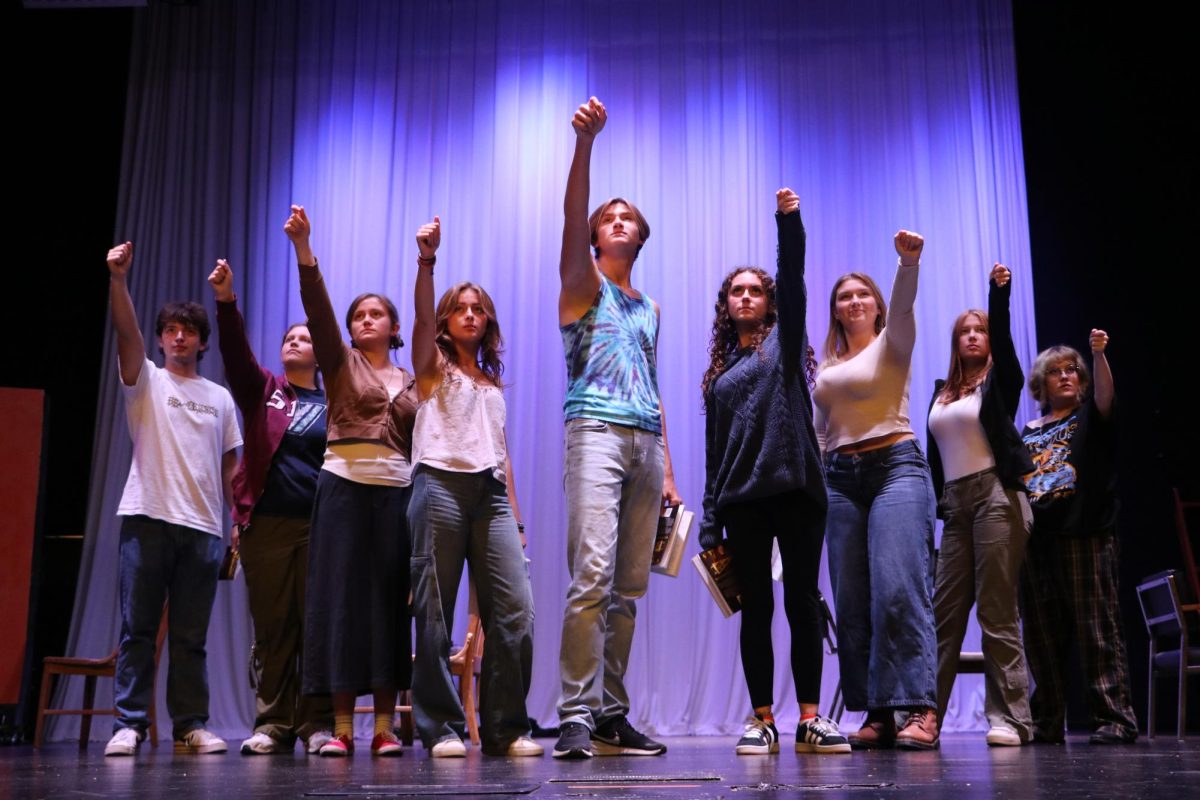 Photo taken by Joshua Ramirez. The main cast of "Puffs" imitates a group of young wizards pointing their wands towards the sky. 