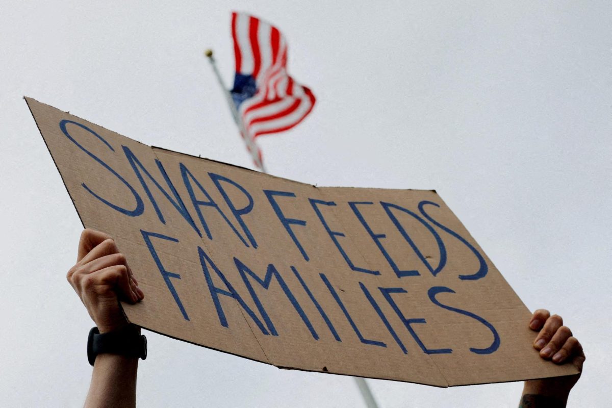 A man holds a sign reading "SNAP Feeds Families," as food aid benefits come under threat due to the ongoing U.S. government shutdown, during "A Rally for SNAP" on the steps of the Massachusetts Statehouse in Boston, Massachusetts, U.S., October 28, 2025. REUTERS/Brian Snyder