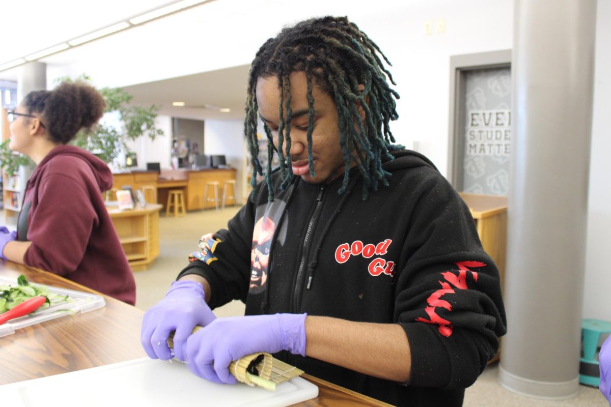 CCHS student rolls a cucumber roll into shape.